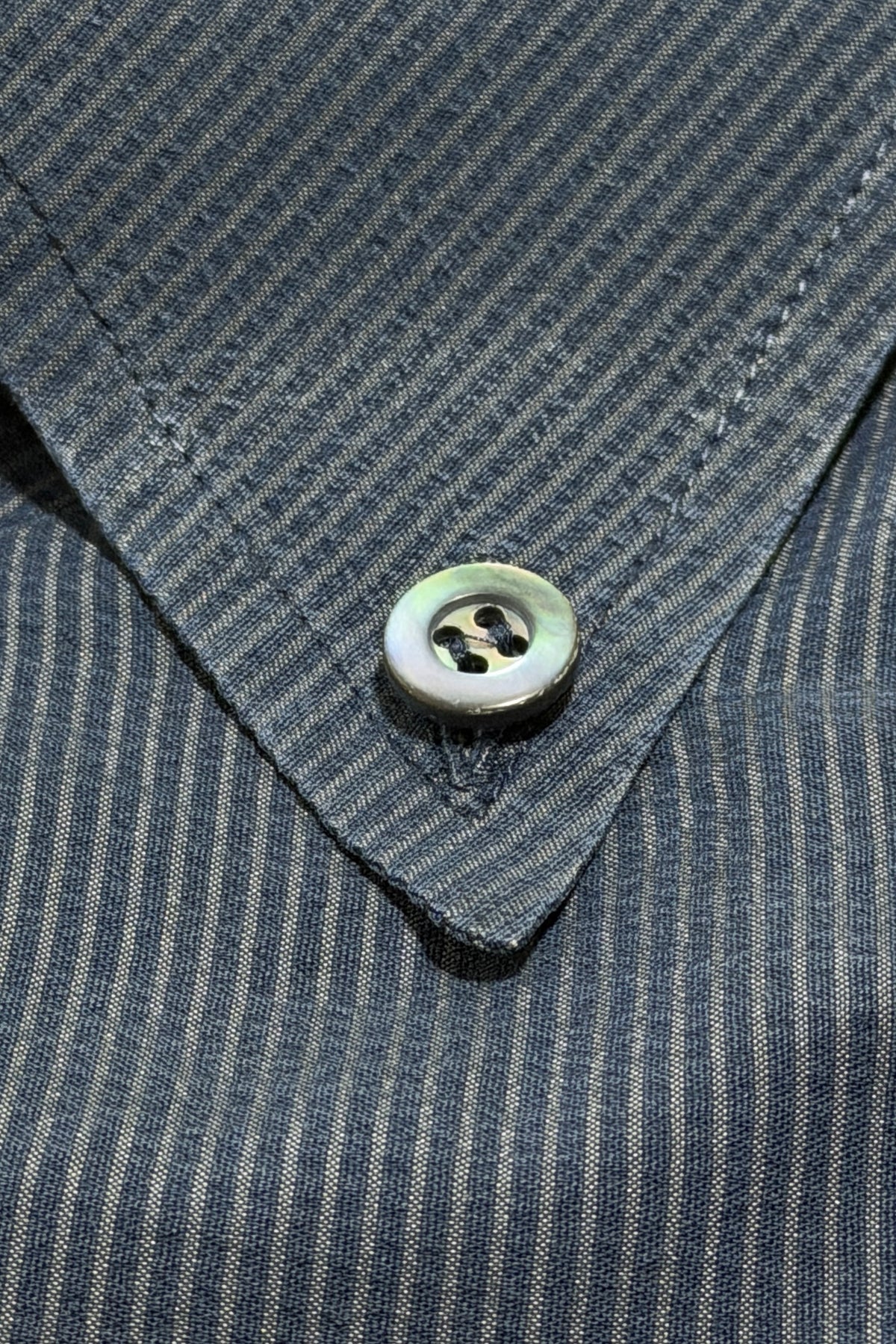 Mother-of-pearl button on button down collar